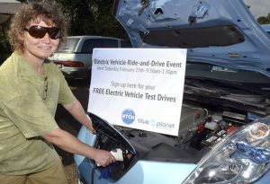 Sonia Kass plugs in the power cord to the Nissan Leaf Saturday during the Kauai Community Market at Kauai Community College.